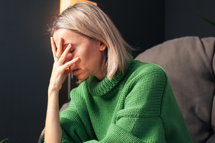 woman with head in hands looking stressed